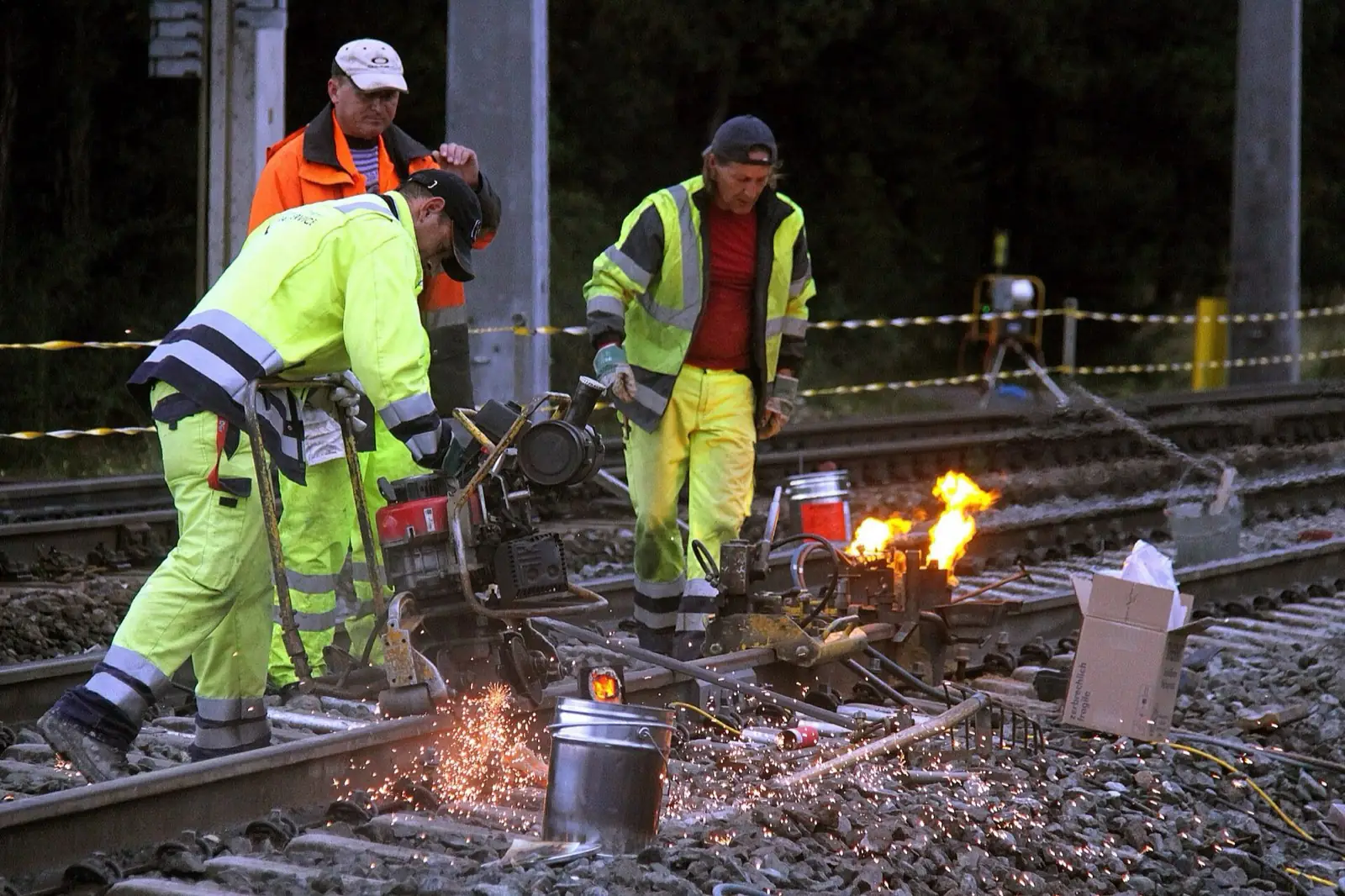 Track crew gathered around a thermite weld in progress