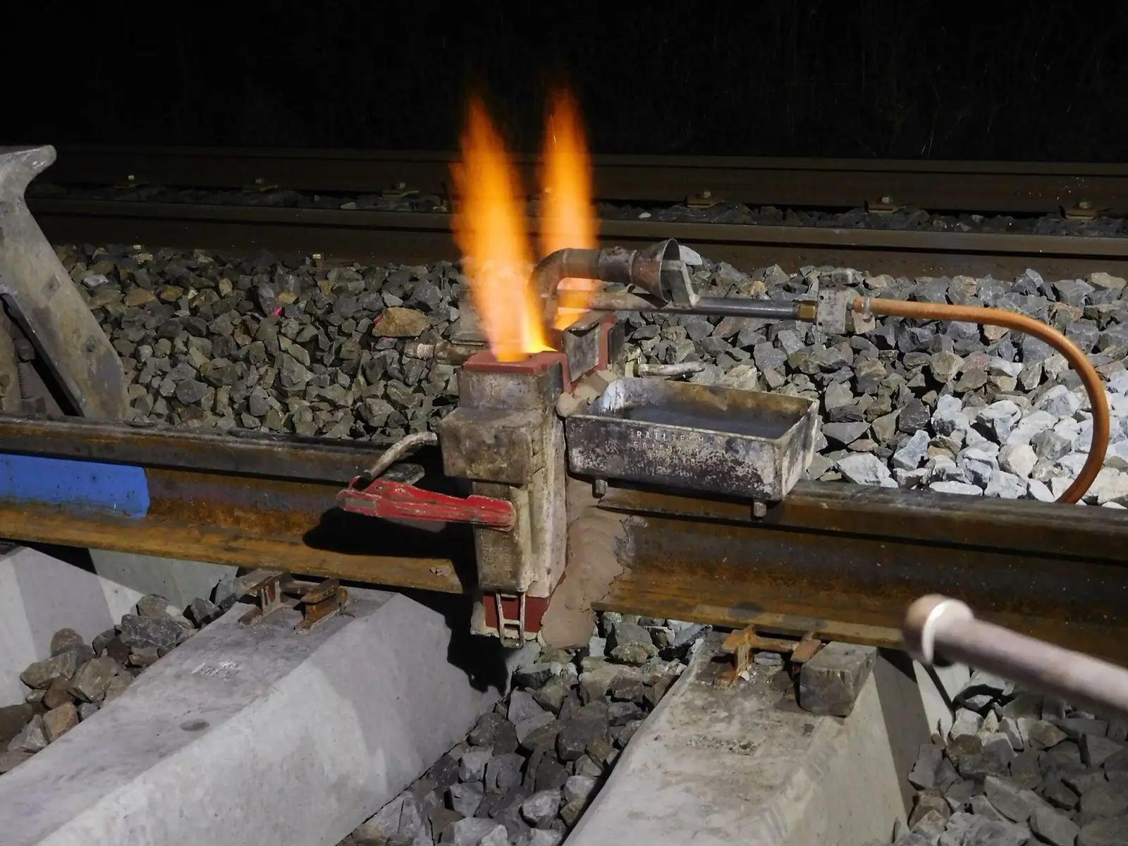 Night thermite welding kit staged on the rail under work lighting